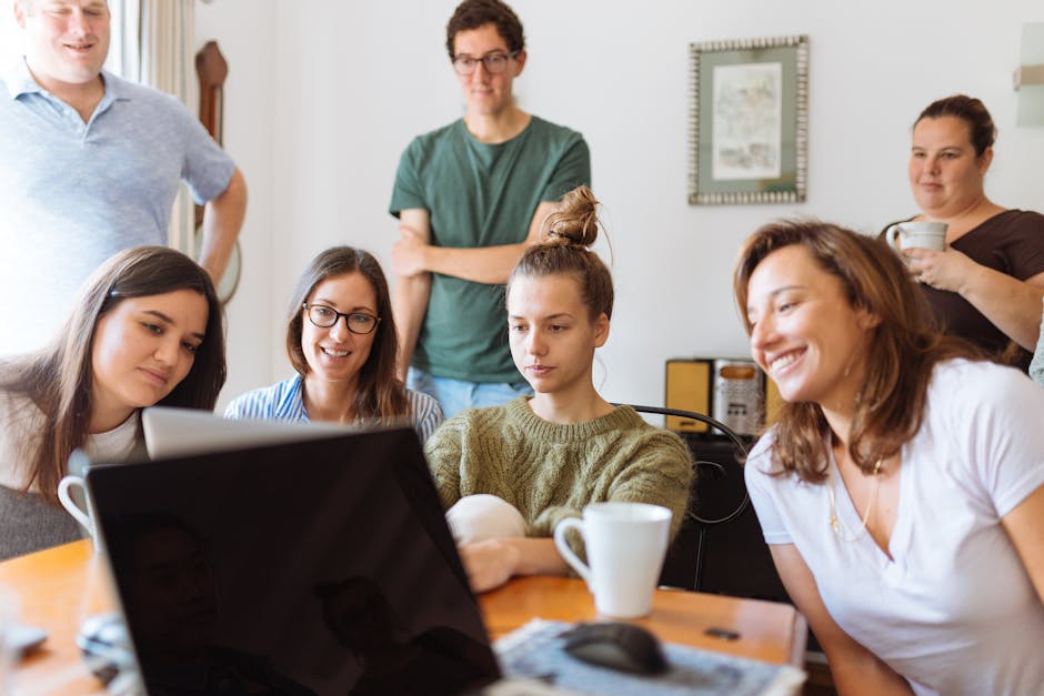 A diverse group of adults at work, enjoying a casual meeting indoors with focus and smiles